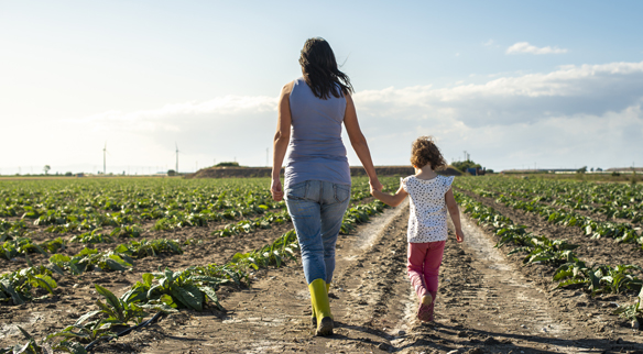 Madre e hija caminando por un camino de tierra