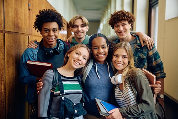 a group of teens standing together in a school hallway